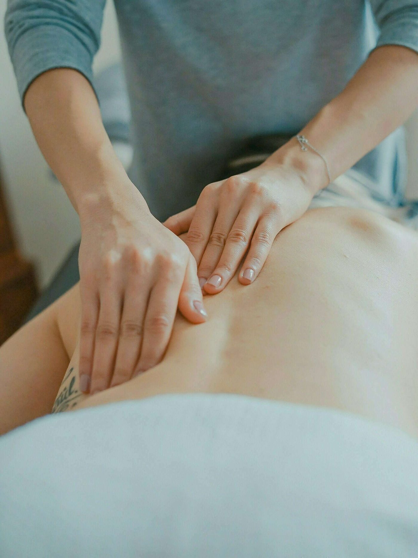 Massage du dos aux huiles essentielles pendant un soin Édonis
