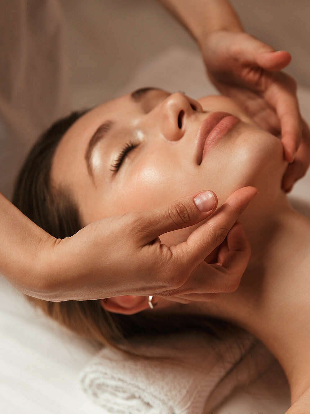 Massage du visage aux huiles essentielles pendant un soin Édonis