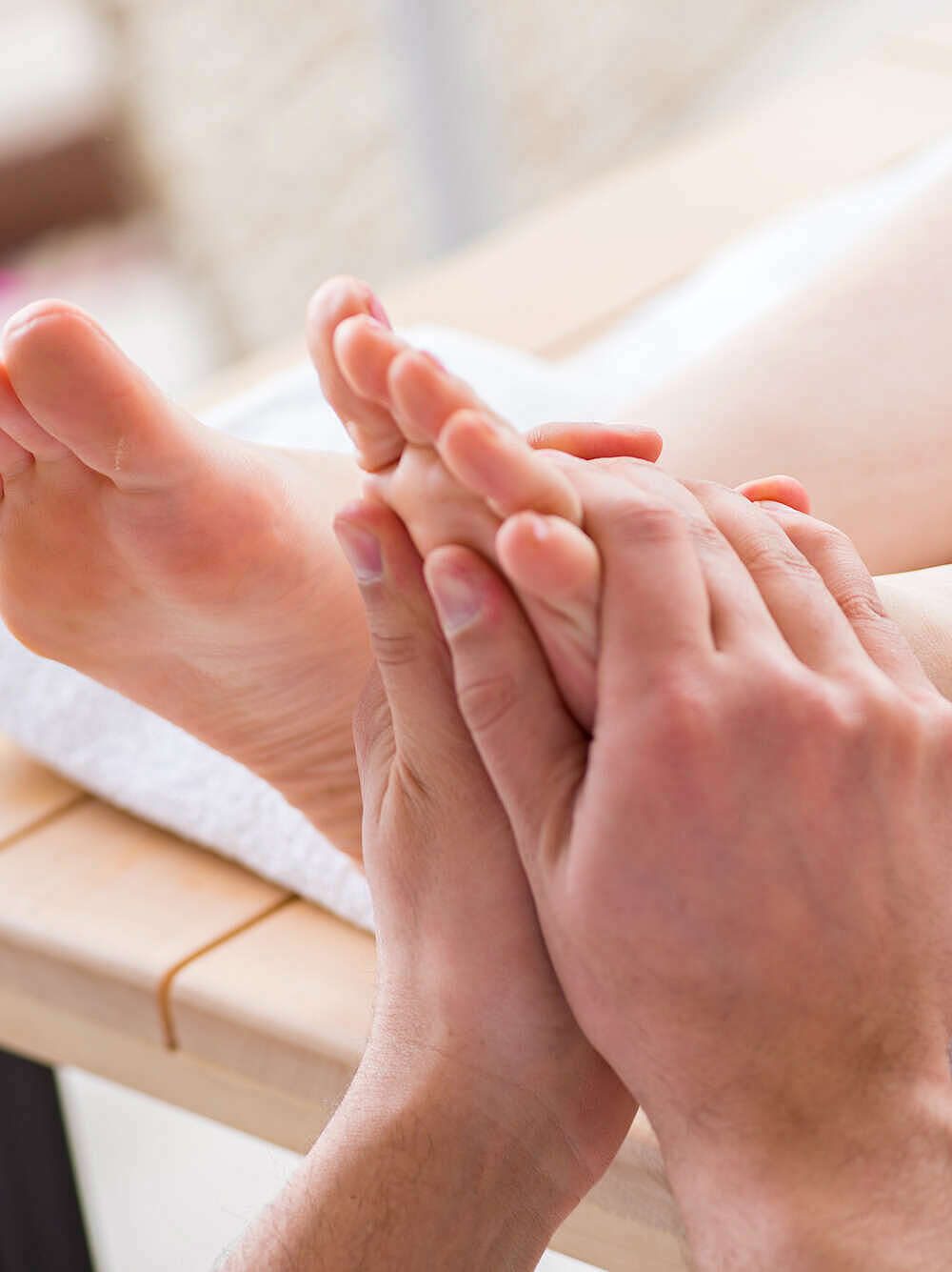 Séance de réflexologie plantaire, pression des pouces sur la voûte du pied